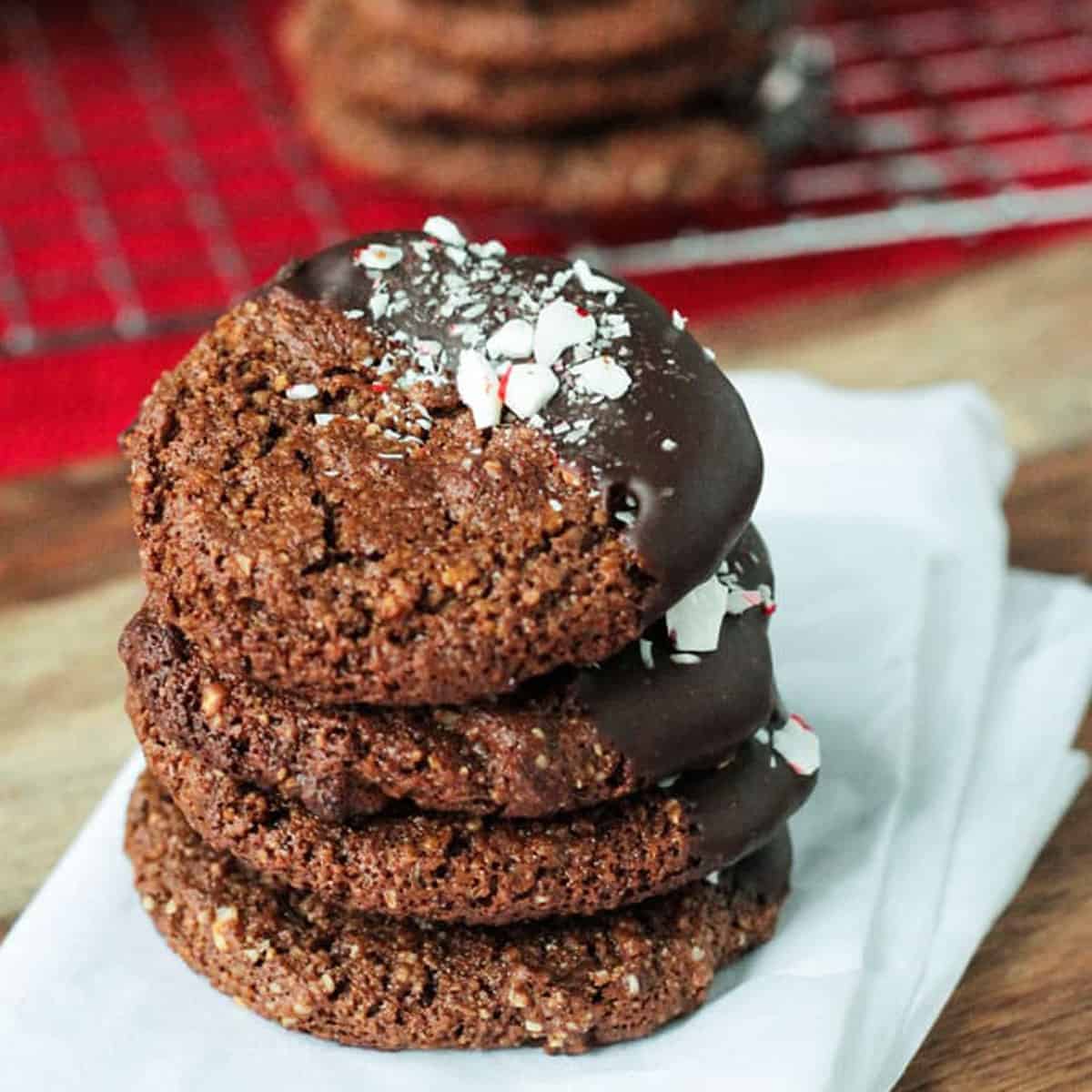 A straight shot of stacked, chewy molasses gingerbread cookies dipped in chocolate and topped with crashed peppermint candies.