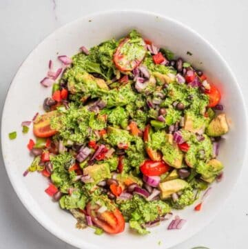 An overhead image of black bean salad with cilantro lime dressing on top in a bowl.
