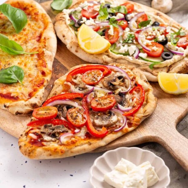 An image of naan pizza with different toppings on each.