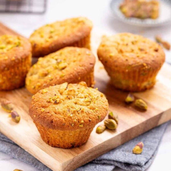 A close up image of pistachio muffins on a serving board.
