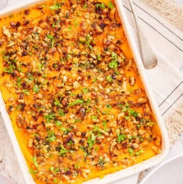 An overhead shot of sweet potato casserole served in a white baking dish.