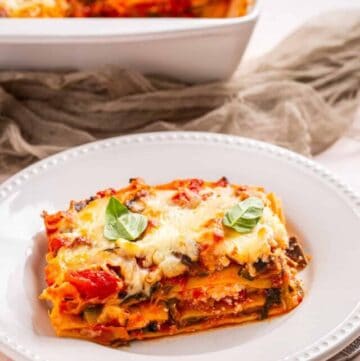An image of a slice of vegetable lasagna in a white serving dish.