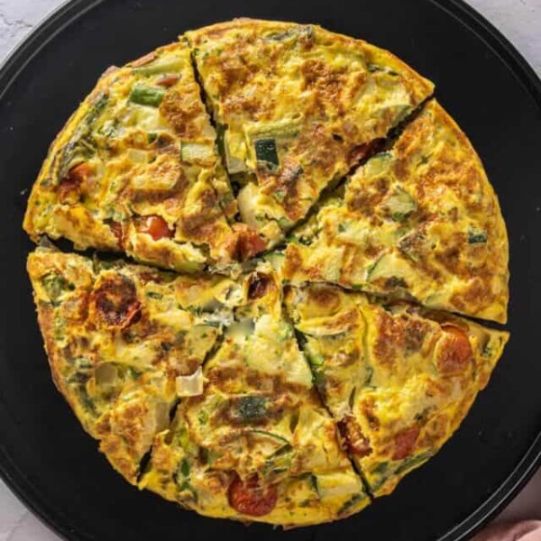 Frittata on a black serving platter with a pink napkin