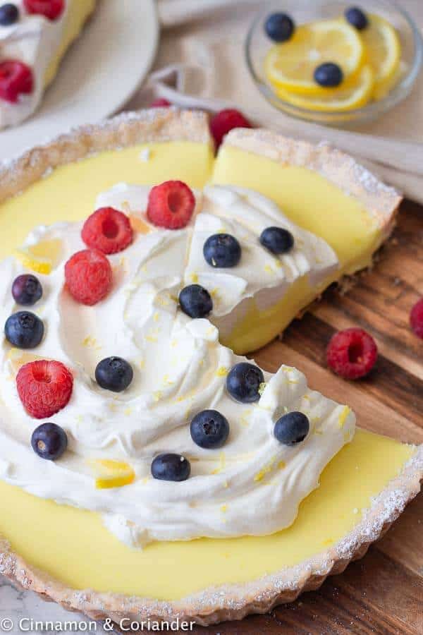 Overhead view of a French lemon tart topped with berries.