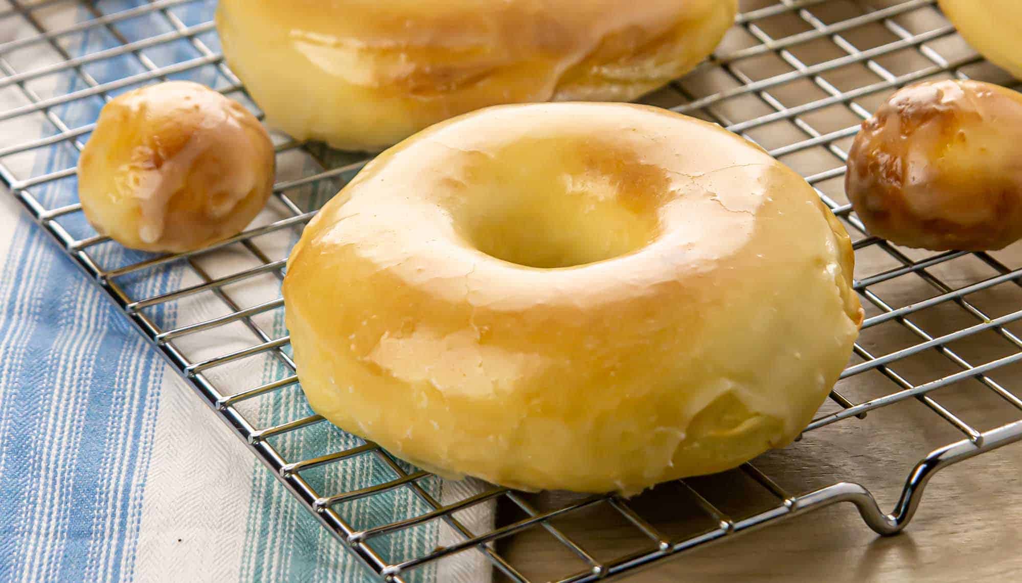 A close-up view of air-fried yeast donuts placed on a wire cooling rack.