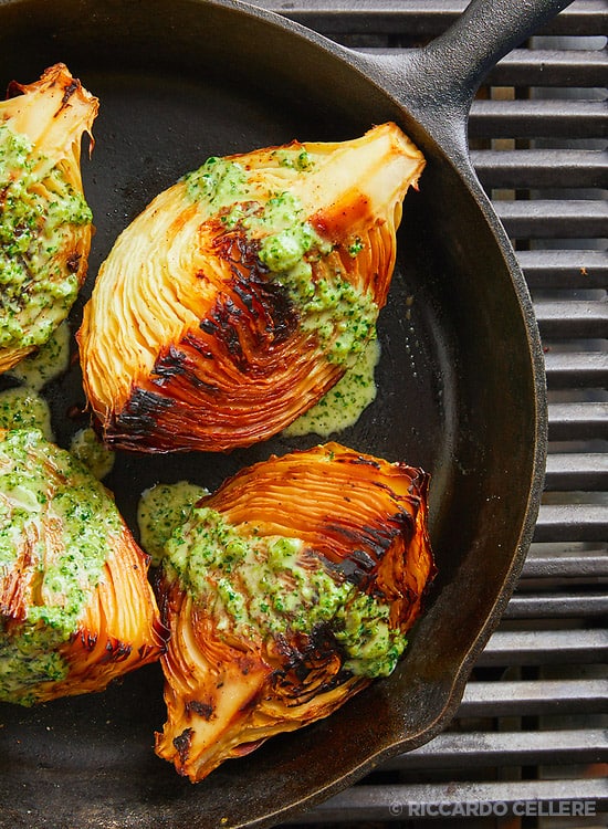 An overhead view of roasted green cabbage placed in a pan.