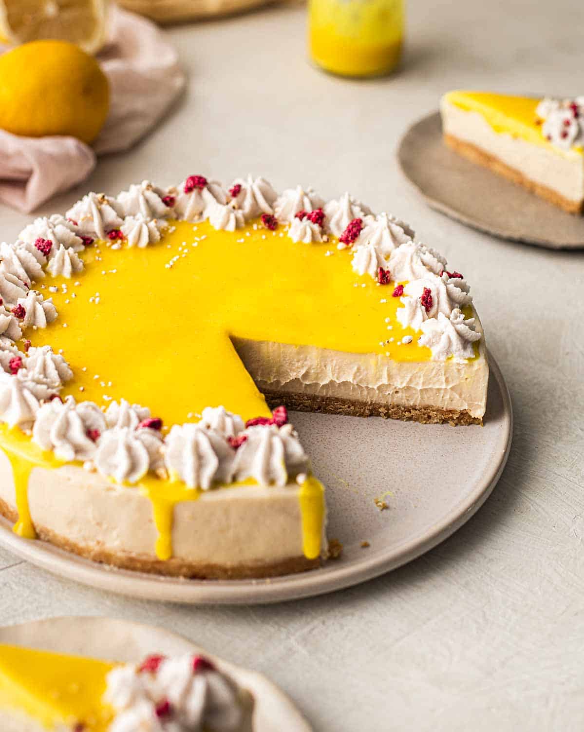 An overhead view of vegan lemon cheesecake with a missing slice that reveals its inside texture.
