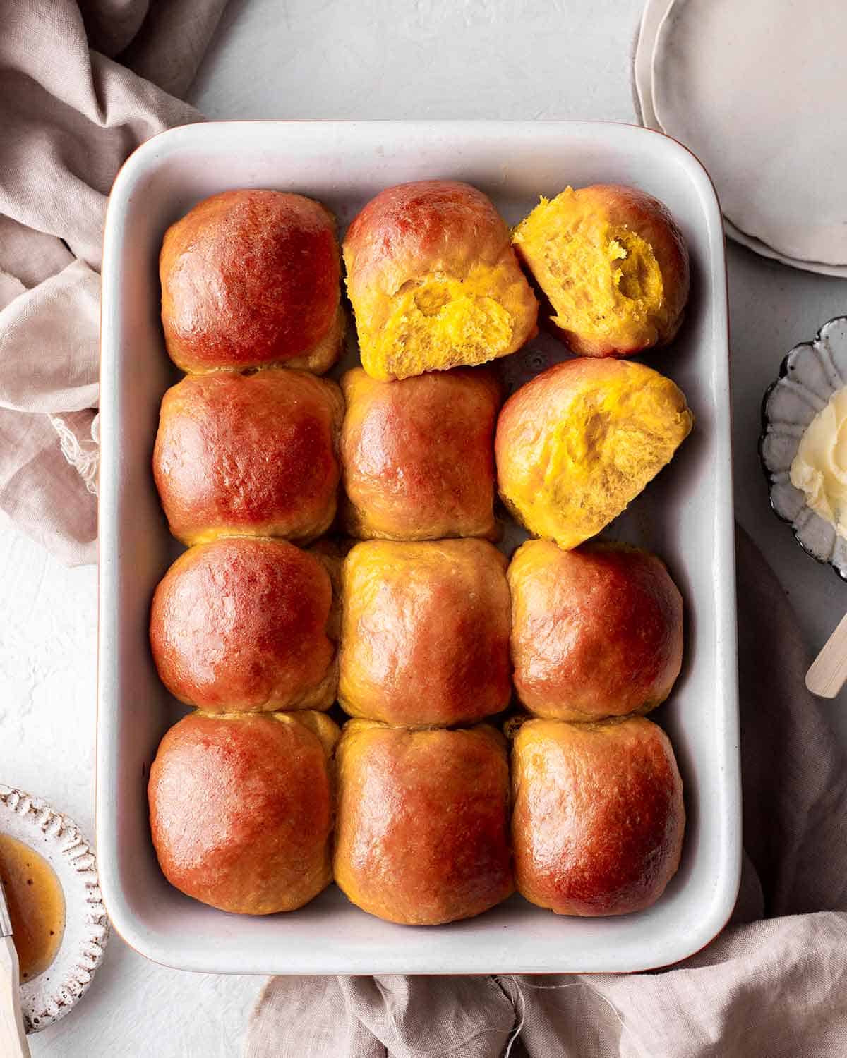 An overhead view of the vegan pumpkin dinner rolls placed on a baking tray.