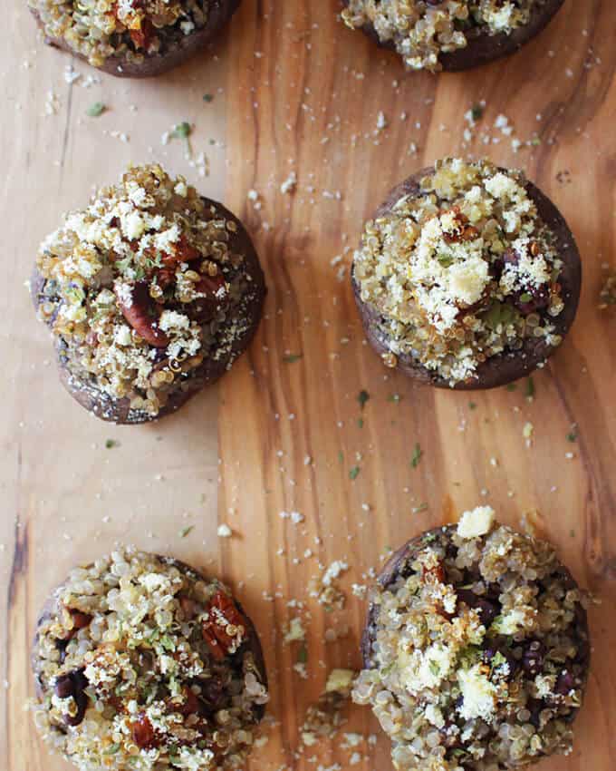 An overhead view of vegan stuffed mushrooms with quinoa placed in a wooden board.