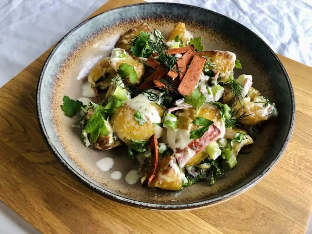 An overhead view of vegan roasted potato salad placed on a plate.